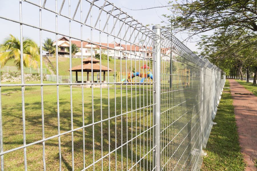 Galvanised mesh fence along a park