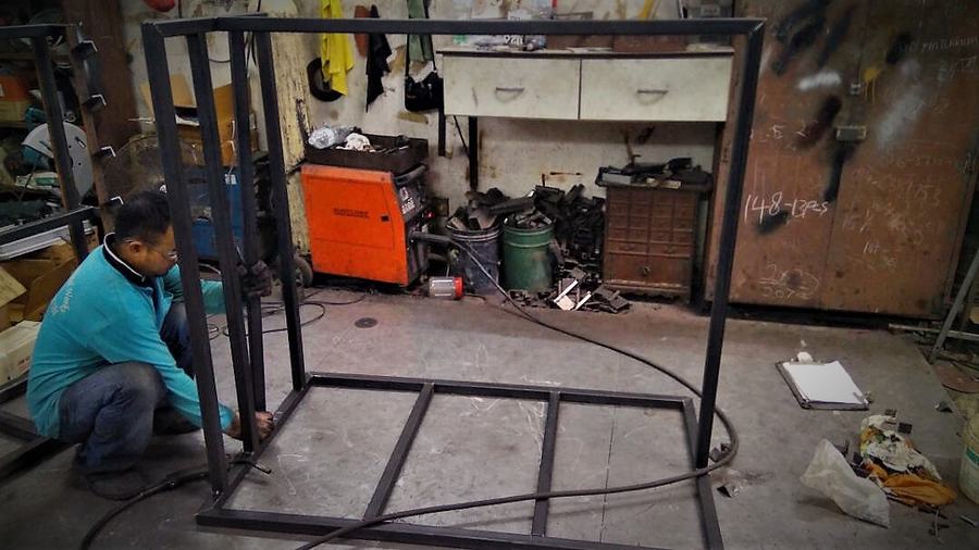 Worker welding a steel frame in the workshop